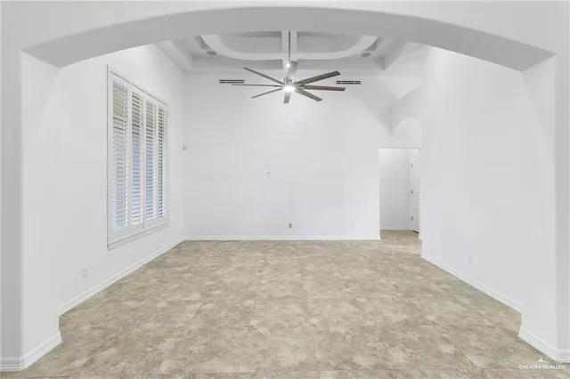 an empty room with windows and fan