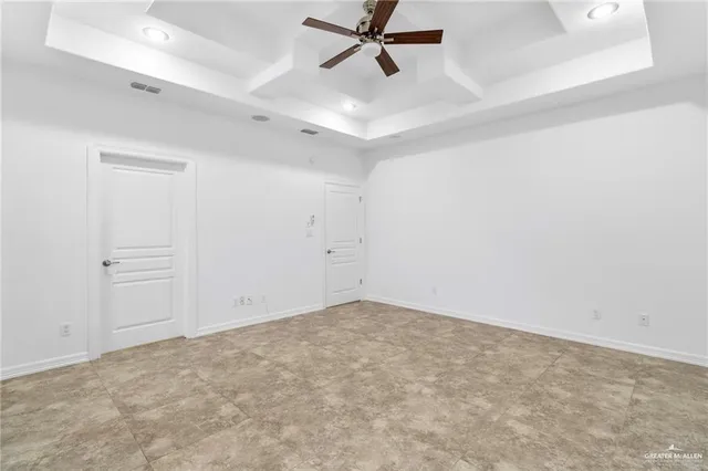 an empty room with a ceiling fan and window