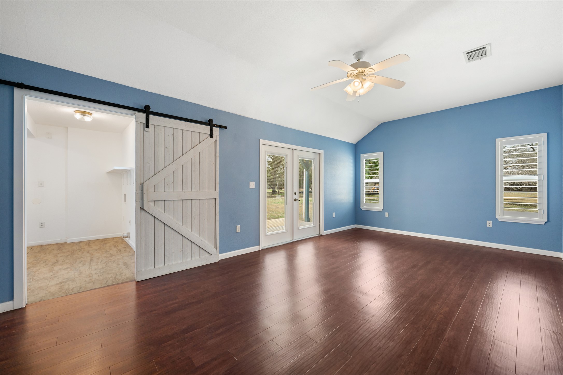 104 Sunset Road Georgetown, TX 78633 - Photo 21 of 40 Unfurnished room featuring a barn door, ceiling fan, lofted ceiling, and dark wood-type flooring