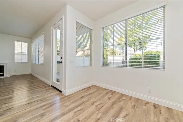 a view of a livingroom with wooden floor and a fireplace