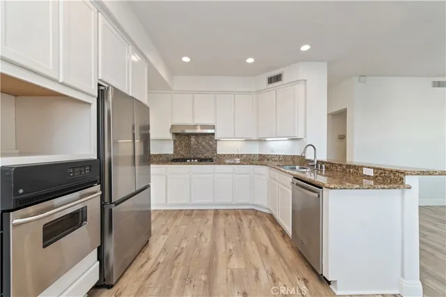 a kitchen with stainless steel appliances and white cabinets