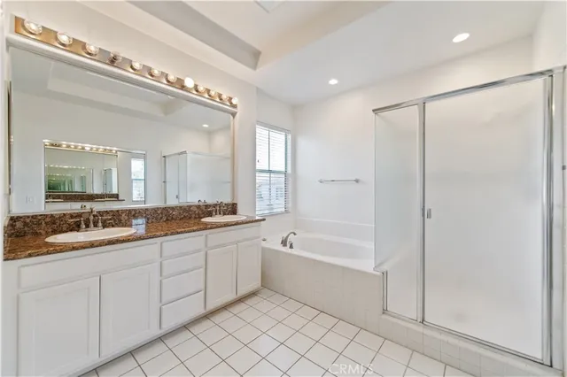 a spacious bathroom with a double vanity sink mirror and bathtub