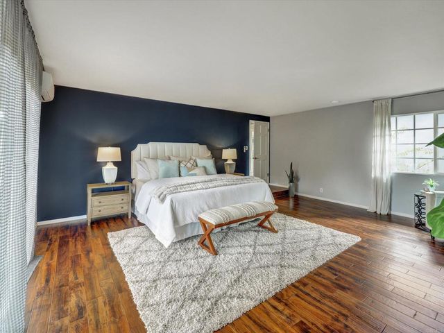 a bedroom with a bed and wooden floor