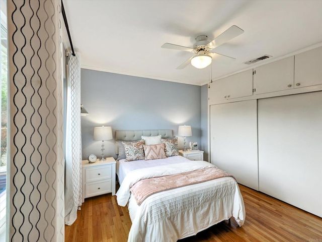 a bedroom with a bed and a lamp on dresser