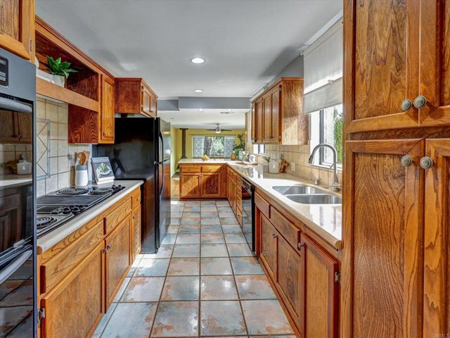 a kitchen with stainless steel appliances granite countertop a sink and a stove