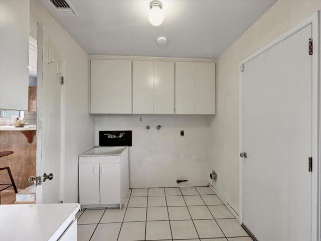a utility room with cabinets washer and dryer