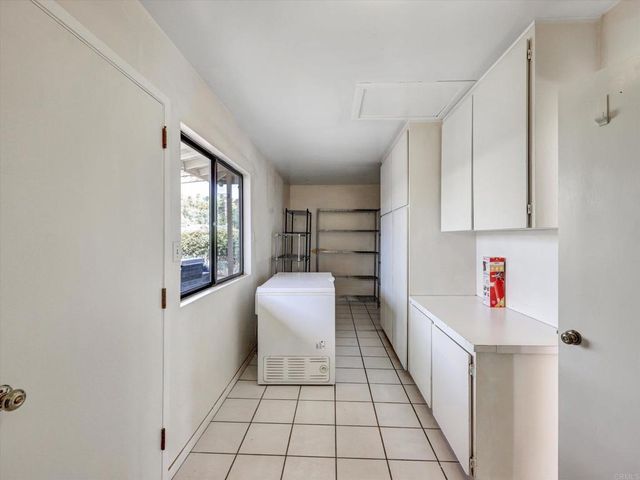 a hallway with a white cabinets and white appliances