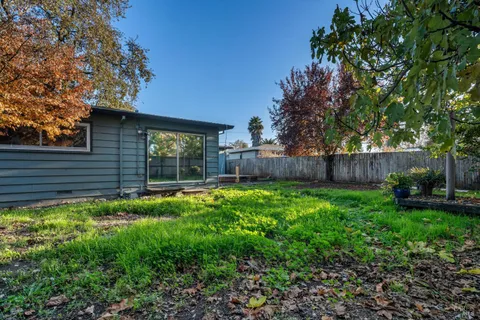 a view of a backyard with table and chairs and wooden fence