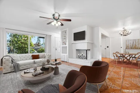 a living room with furniture a fireplace and a large window