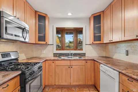 a kitchen with stainless steel appliances granite countertop a stove a sink and a microwave