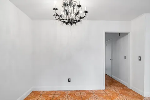 a view of a small space with wooden floor and a chandelier