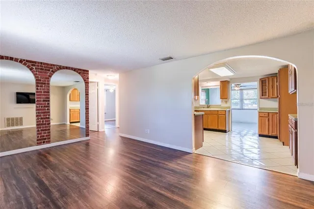 a view of empty room with wooden floor and fireplace