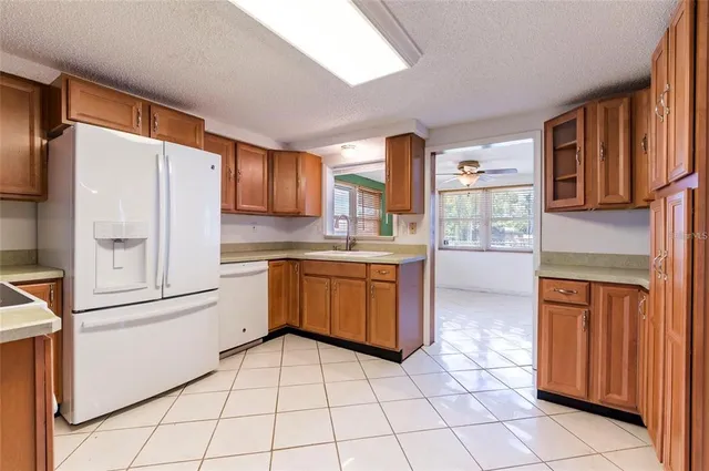 a kitchen with a refrigerator sink and cabinets