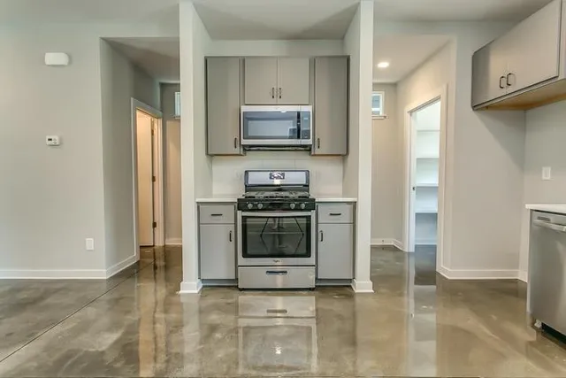 a kitchen with granite countertop a stove and a refrigerator