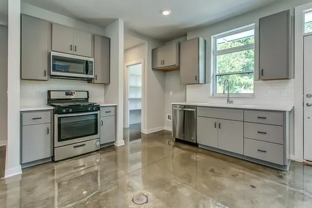 a kitchen with stainless steel appliances a stove sink and microwave