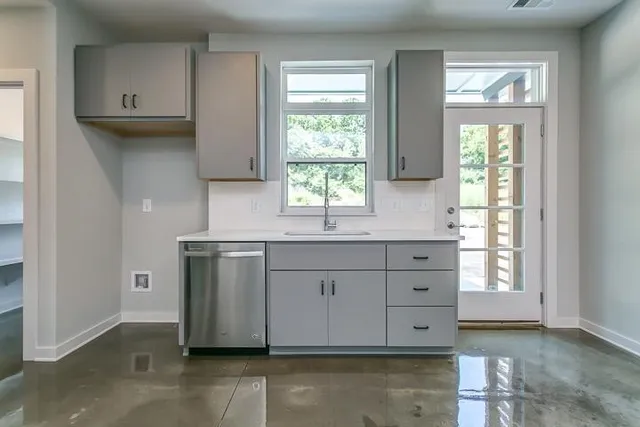 a kitchen with granite countertop white cabinets and window