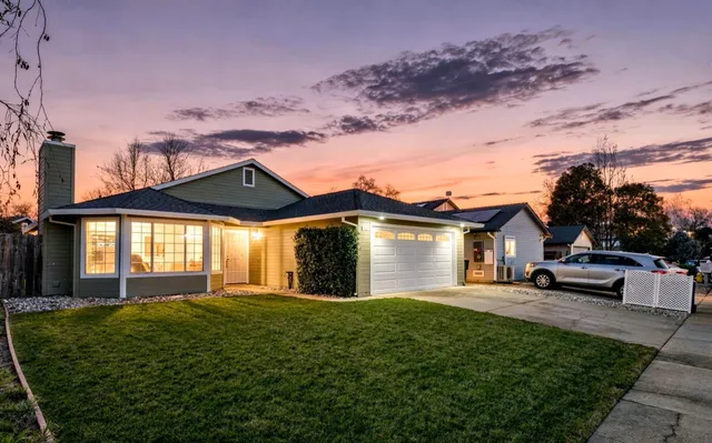 a front view of a house with a yard and potted plants
