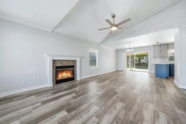 a view of a livingroom with wooden floor and a fireplace