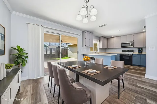 a kitchen with a table chairs stainless steel appliances and cabinets