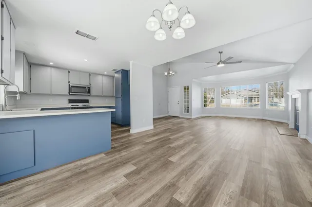 a kitchen with kitchen island granite countertop a stove sink and cabinets