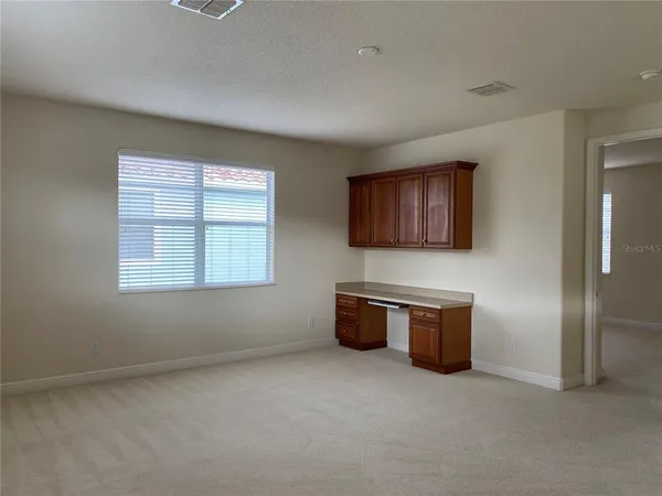 a view of a big room with wooden floor and windows