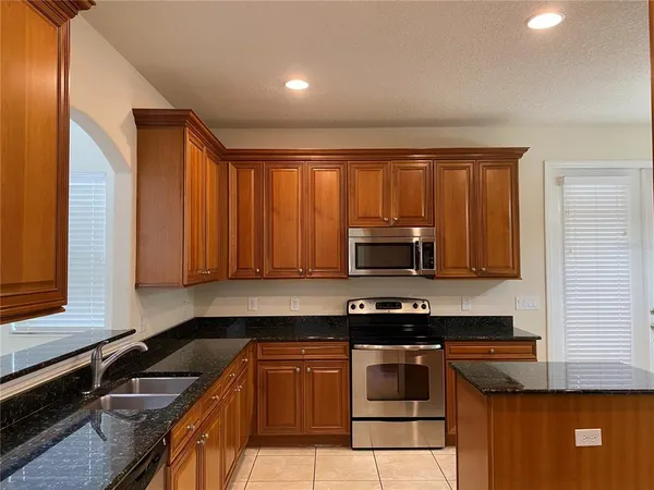 a kitchen with stainless steel appliances granite countertop a refrigerator and a stove top oven
