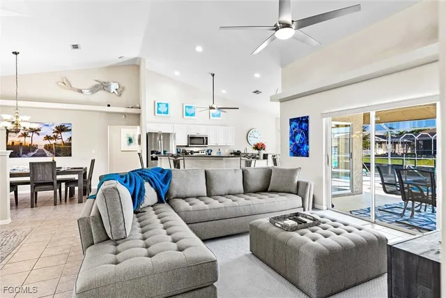 a living room with furniture kitchen view and a chandelier