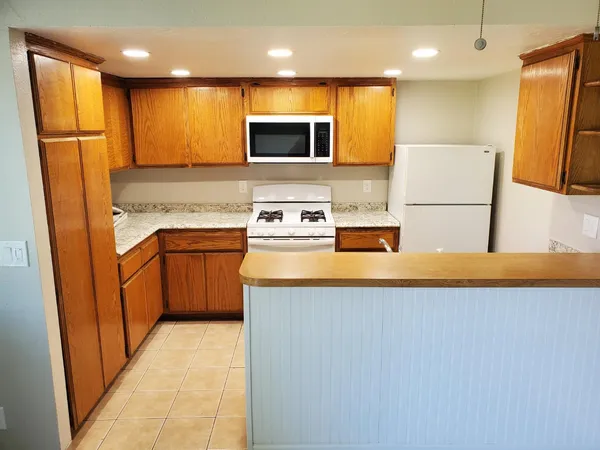 a kitchen with stainless steel appliances granite countertop a stove a sink and a refrigerator