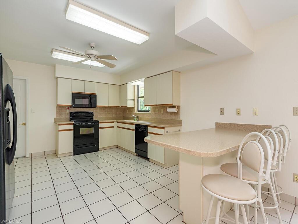 177 6th Street Naples, FL 34113 - Photo 4 of 16 a kitchen with granite countertop stainless steel appliances cabinets a sink and a counter top space