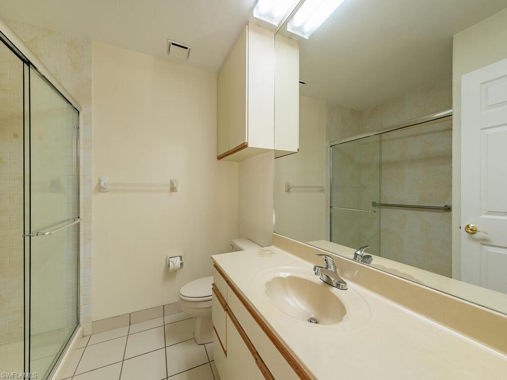 177 6th Street Naples, FL 34113 - Photo 7 of 16 a bathroom with a granite countertop sink a toilet and shower
