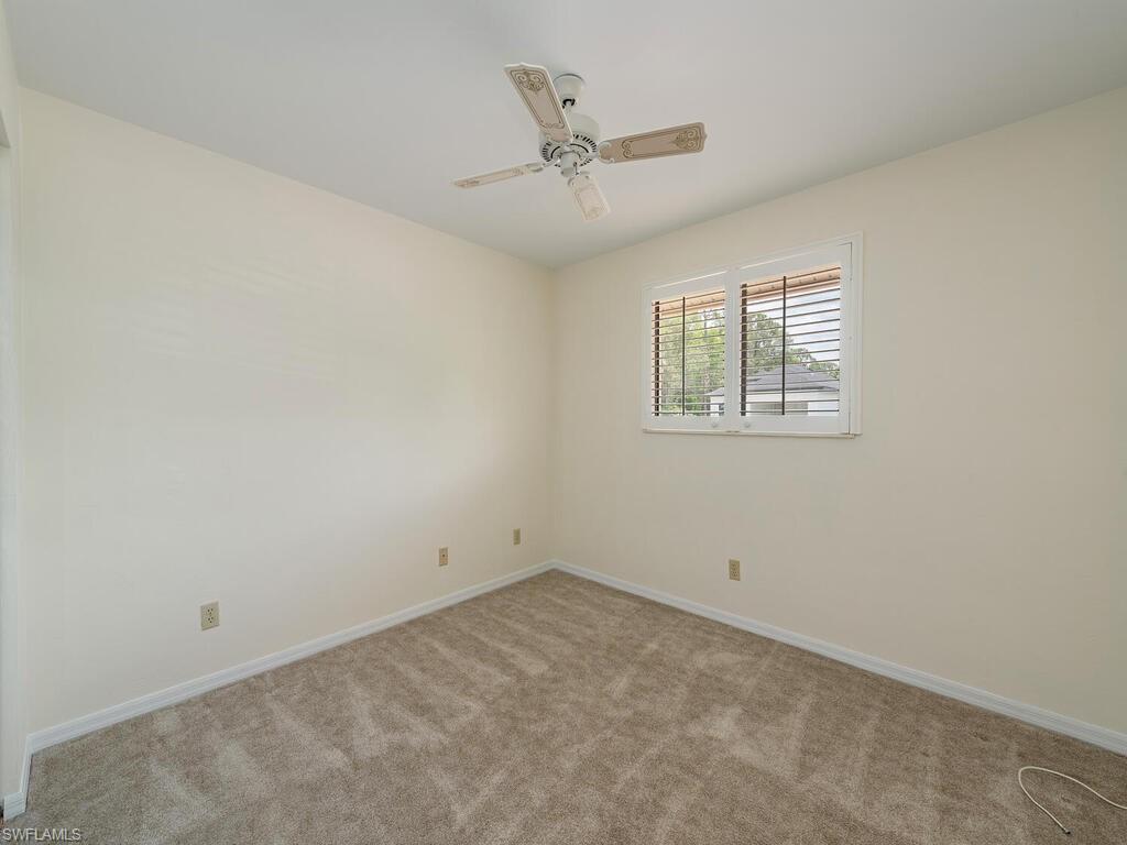 177 6th Street Naples, FL 34113 - Photo 8 of 16 an empty room with a ceiling fan and window