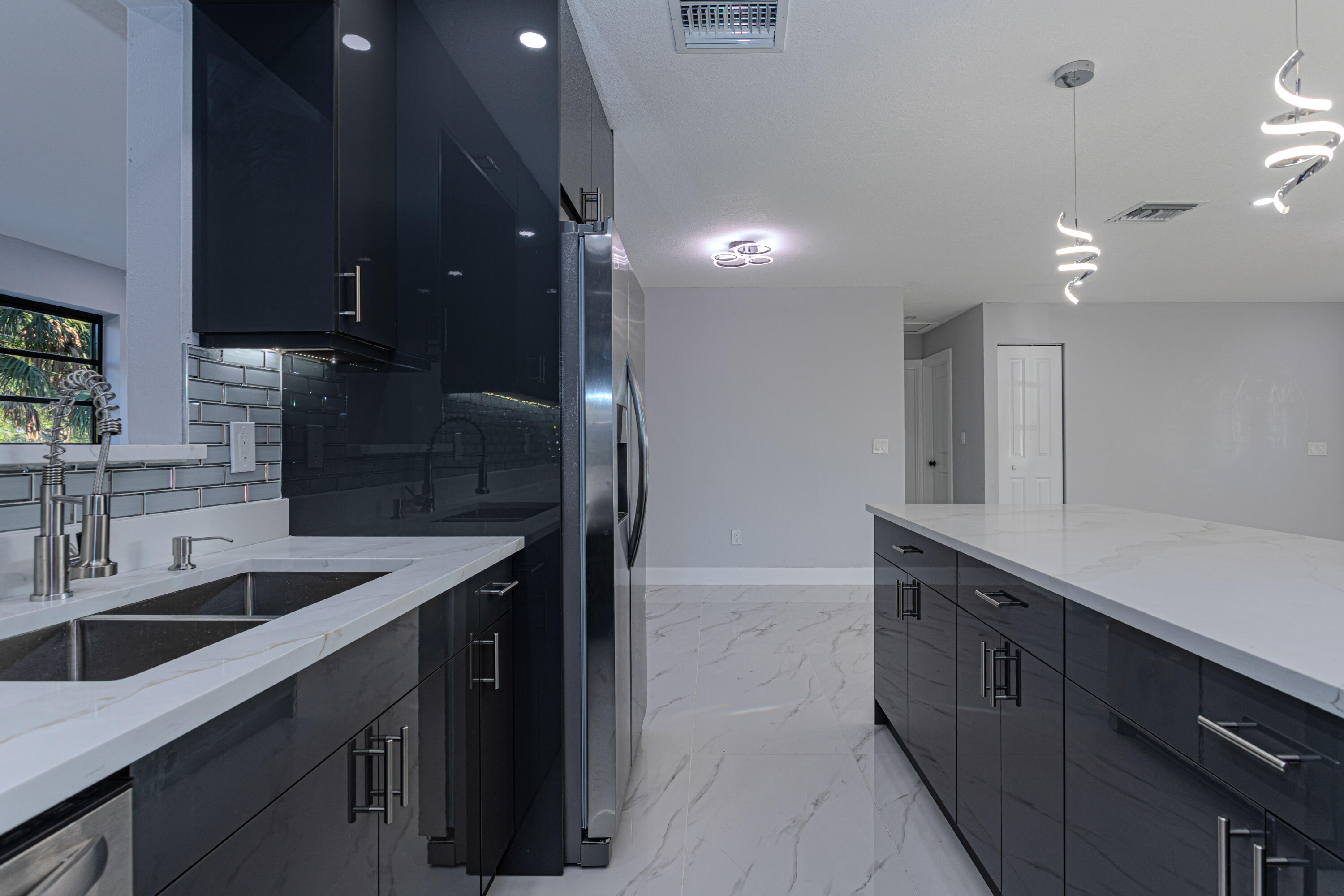 62 Andros Road Palm Springs, FL 33461 - Photo 11 of 41 a kitchen with counter top space cabinets and stainless steel appliances