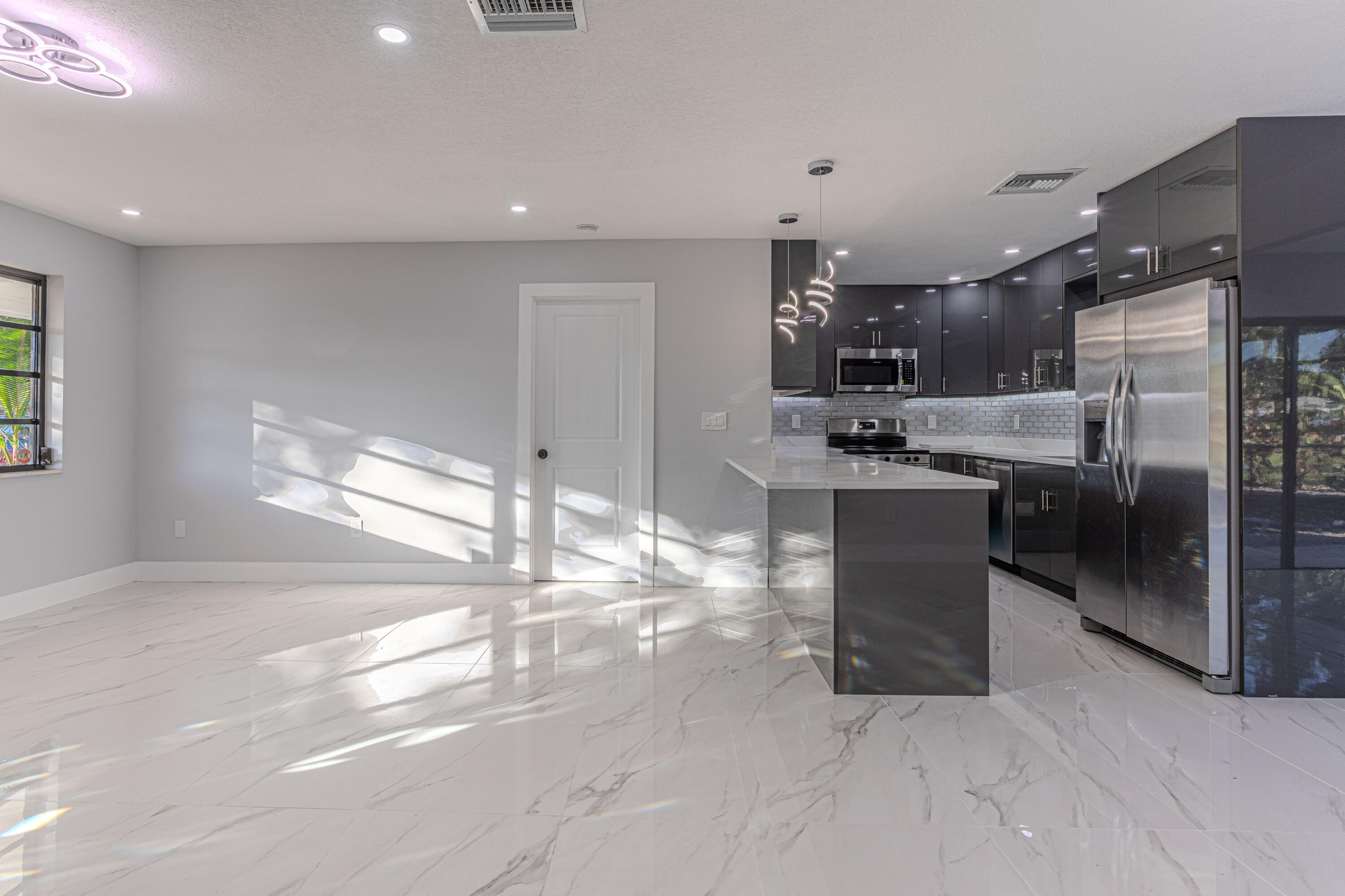 62 Andros Road Palm Springs, FL 33461 - Photo 7 of 41 a kitchen with stainless steel appliances kitchen island granite countertop a sink and cabinets
