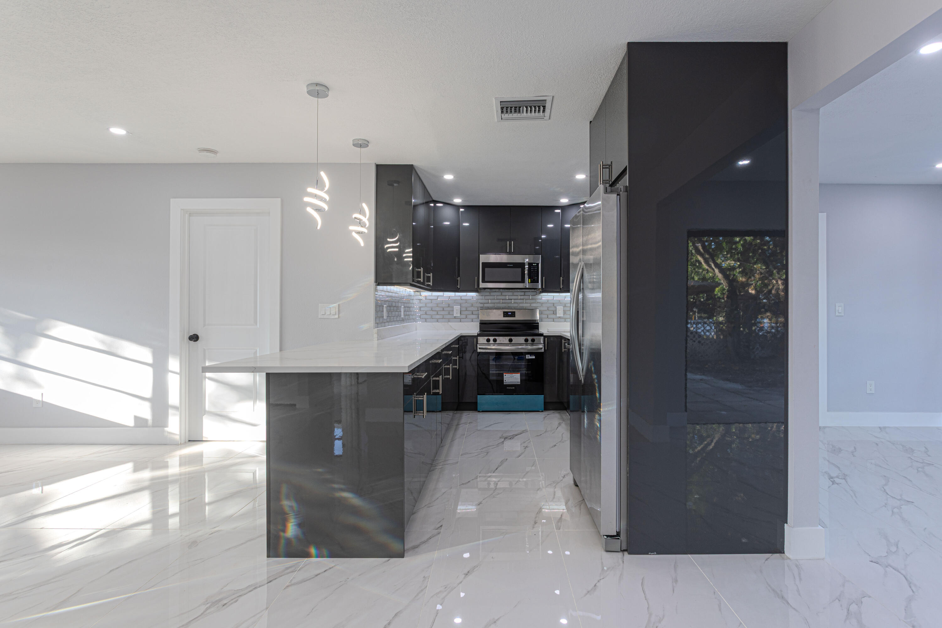 62 Andros Road Palm Springs, FL 33461 - Photo 8 of 41 a kitchen with stainless steel appliances kitchen island granite countertop a refrigerator and a sink