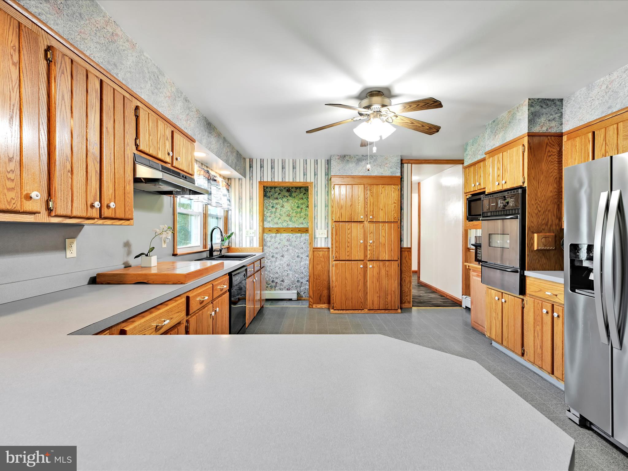 7932 Jonestown Road Harrisburg, PA 17112 - Photo 8 of 79 a kitchen with stainless steel appliances granite countertop a refrigerator a oven a sink dishwasher and a dining table with wooden floor