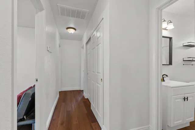 a view of a hallway with wooden floor and staircase