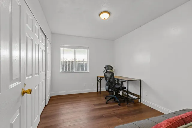 a view of a room with gym equipment and wooden floor