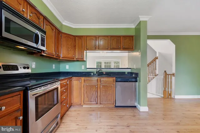 a kitchen with stainless steel appliances granite countertop a stove a sink and a microwave