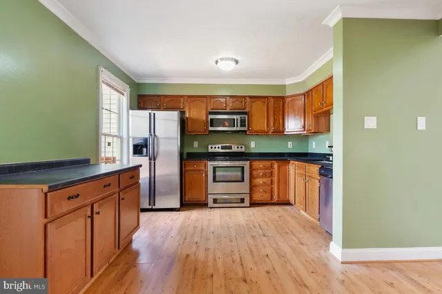 a kitchen with stainless steel appliances granite countertop a refrigerator and a stove top oven