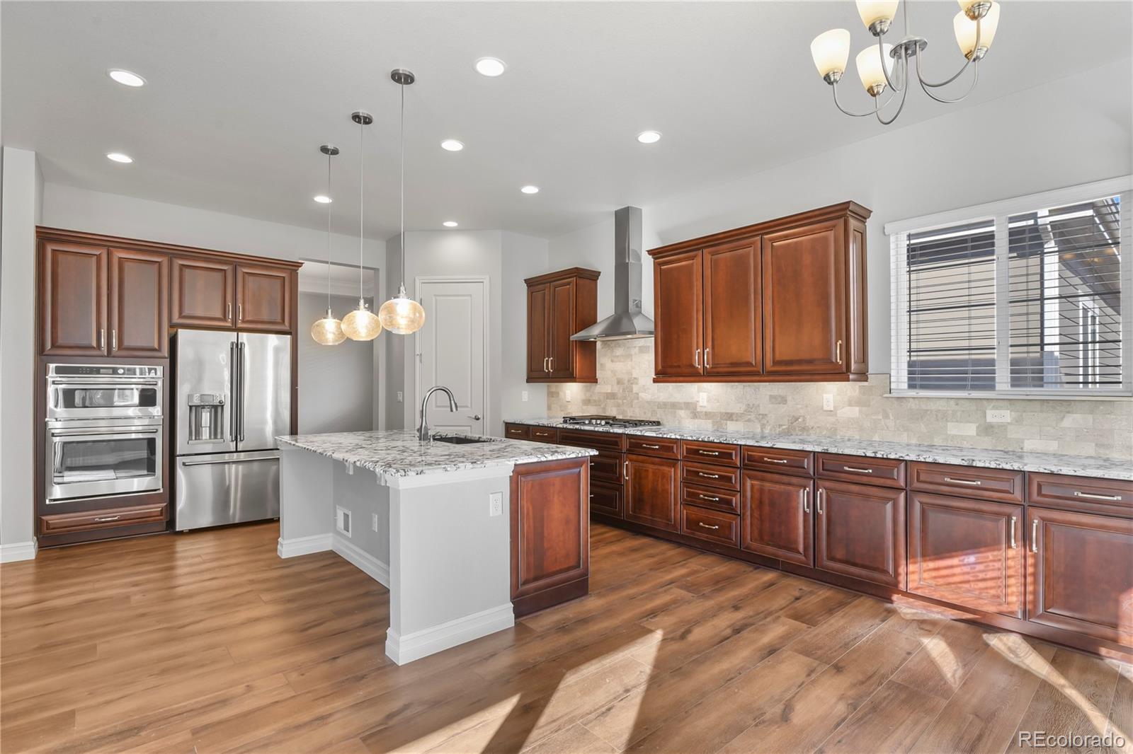 12938 Bridge View Lane Parker, CO 80134 - Photo 12 of 47 a large kitchen with stainless steel appliances granite countertop a sink and cabinets