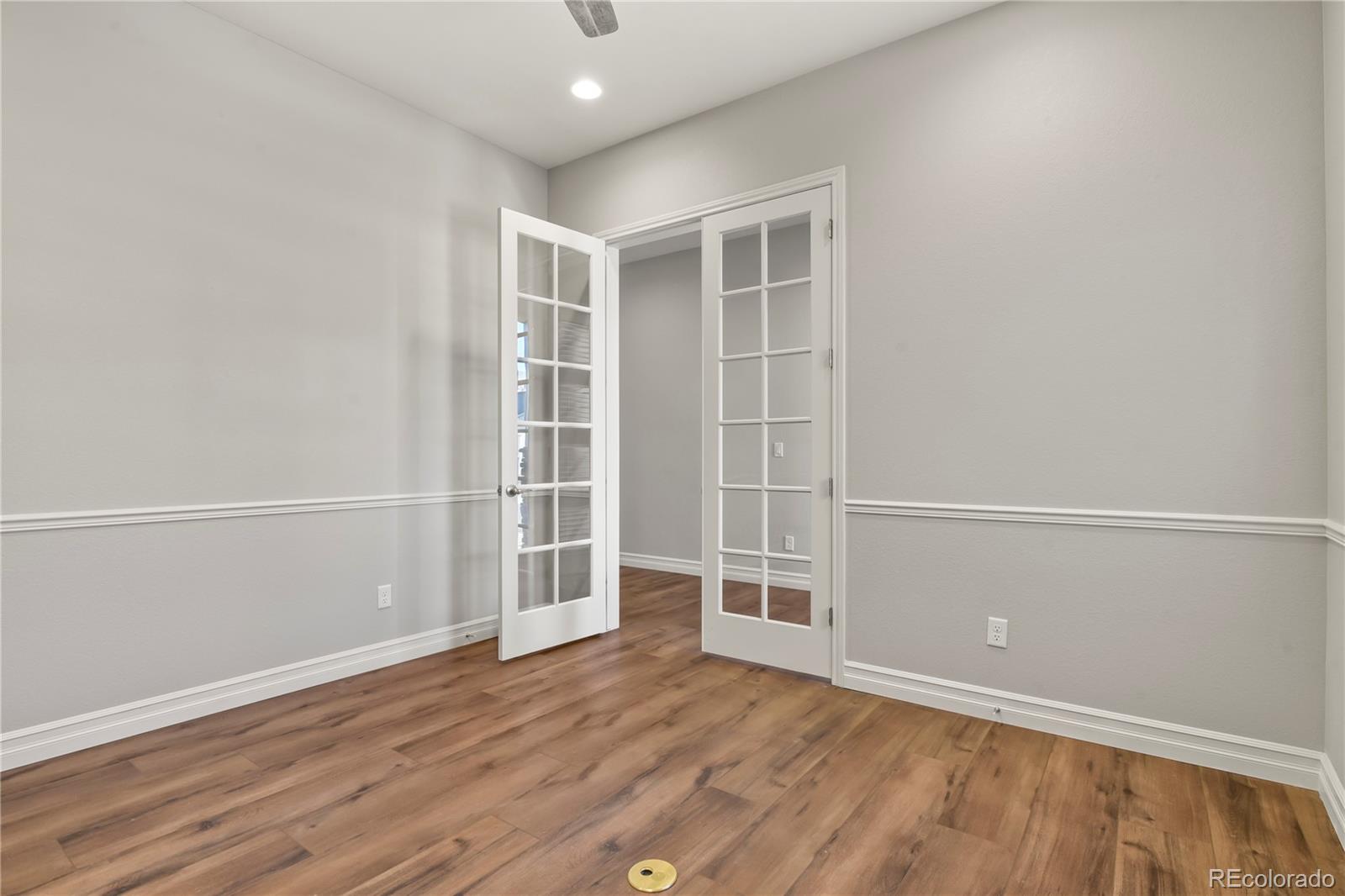 12938 Bridge View Lane Parker, CO 80134 - Photo 20 of 47 an empty room with wooden floor and white walls