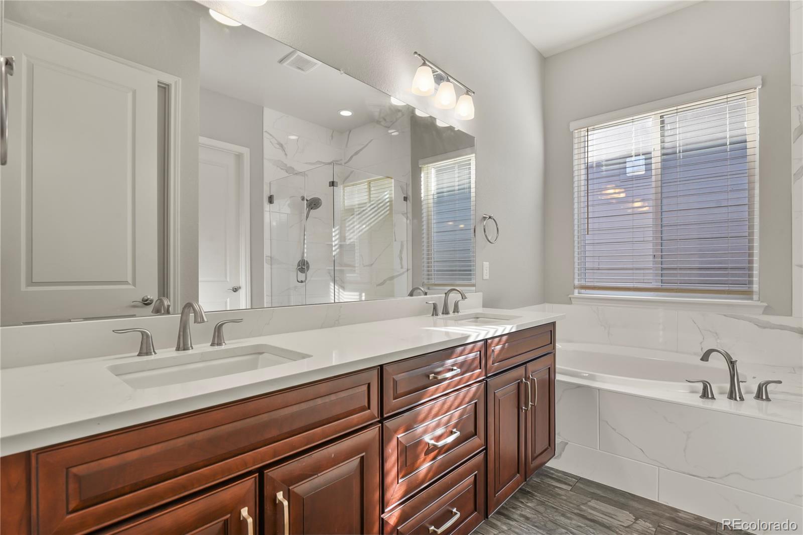 12938 Bridge View Lane Parker, CO 80134 - Photo 23 of 47 a bathroom with a sink double vanity granite tub shower and a mirror