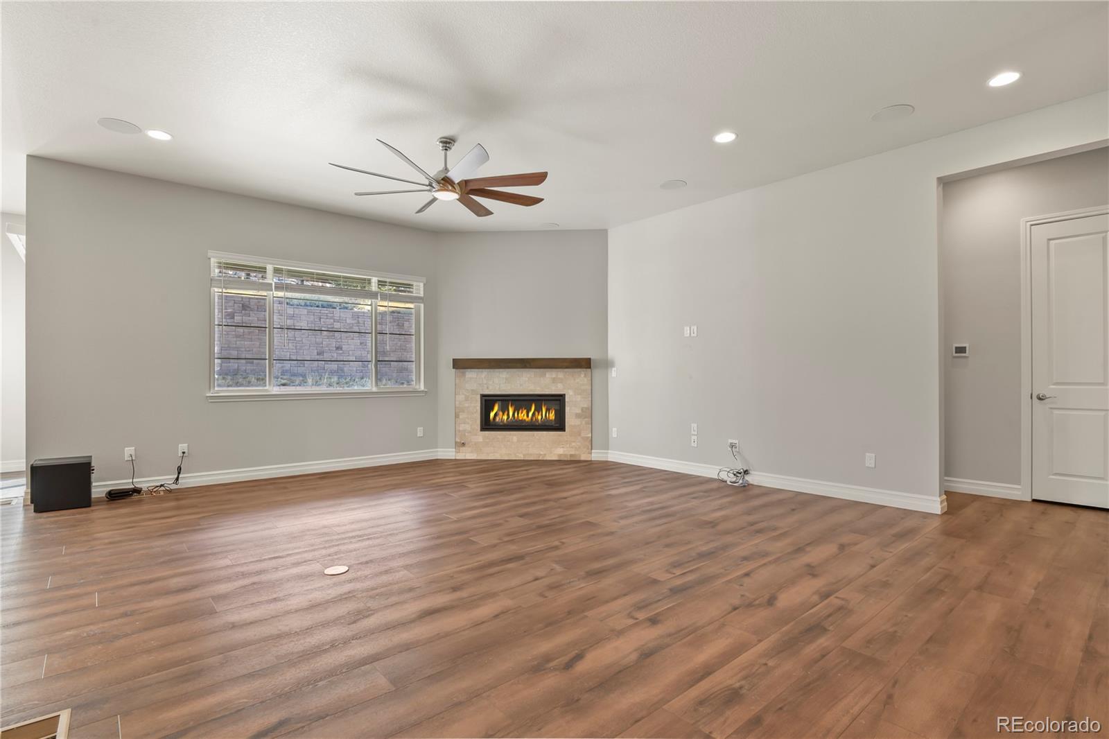 12938 Bridge View Lane Parker, CO 80134 - Photo 5 of 47 an empty room with wooden floor ceiling fan and windows