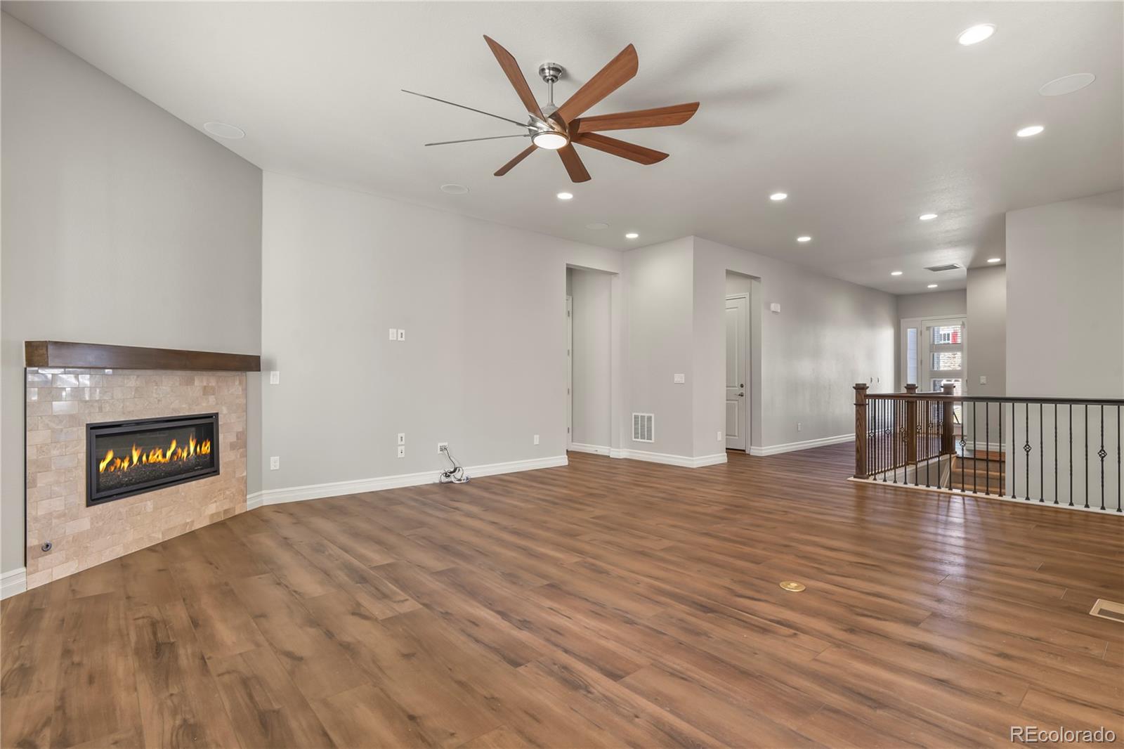 12938 Bridge View Lane Parker, CO 80134 - Photo 7 of 47 a view of an empty room with a fireplace and a ceiling fan