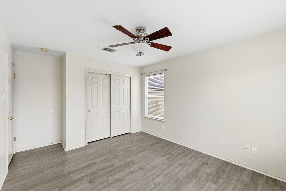 910 Kirtomy Loop Pflugerville, TX 78660 - Photo 12 of 37 a view of an empty room with wooden floor and a ceiling fan
