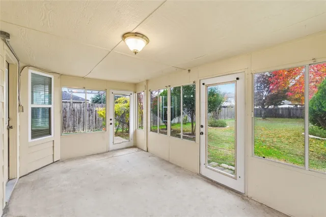 a view of an empty room with wooden floor and a floor to ceiling window