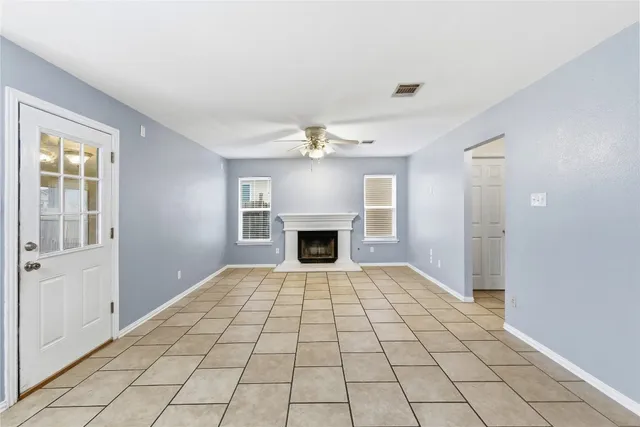 a view of an empty room with a fireplace and a window