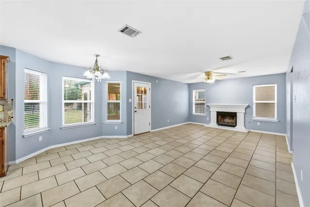 a view of an empty room with a fireplace and a window
