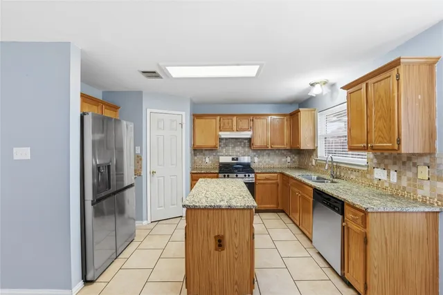 a kitchen with a sink refrigerator and cabinets