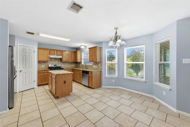 a large bedroom with a large bed chandelier and closet